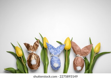 Flat lay composition with Easter bunnies made of paper and eggs on white background. Space for text - Powered by Shutterstock