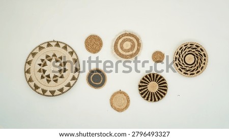 ⁠Minimalist flat lay composition of ethnic handmade woven plates with geometric patterns hanging on a clean white wall,