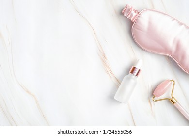 Flat Lay Composition With Eye Mask For Sleep, Serum And Face Roller On Marble Background. Anti-aging Night Lotion For Face, Night Skincare Routine Concept