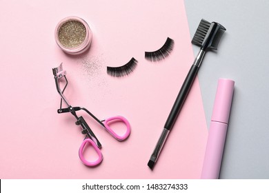 Flat lay composition with false eyelashes and other makeup products on color background