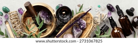 Flat lay composition featuring amethyst crystals, essential oil bottles, incense sticks, sage smudge bundle, massage balls, and a singing bowl on a light background, symbolizing wellness, mindfulness, and natural healing rituals.