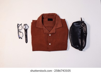 A flat lay composition featuring a light brown Cuban short-sleeved shirt as the central element.
