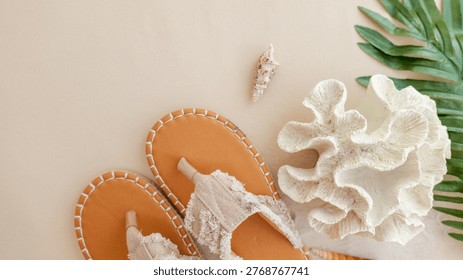 A flat lay composition featuring tan espadrille sandals, delicate seashells, and a piece of white coral, evoking a serene beach vacation vibe