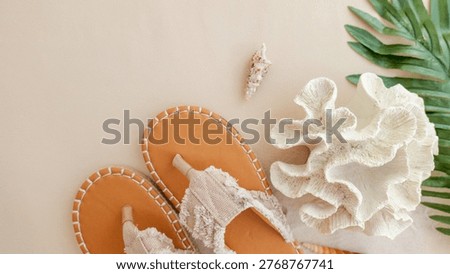 A flat lay composition featuring tan espadrille sandals, delicate seashells, and a piece of white coral, evoking a serene beach vacation vibe
