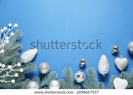Flat lay composition with fir tree branches and other Christmas decor on blue background, space for text