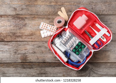Flat lay composition with first aid kit and space for text on wooden background