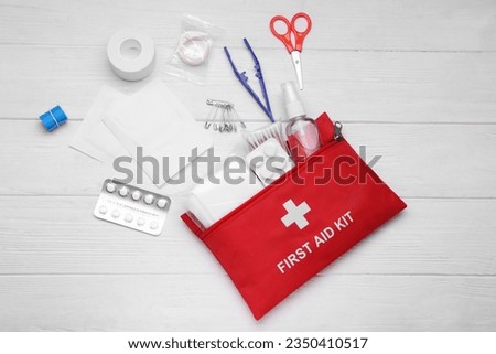 Flat lay composition with first aid kit on white wooden table