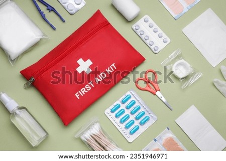 Flat lay composition with first aid kit on light green background