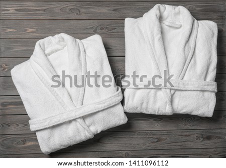 Flat lay composition with folded bathrobes on wooden background