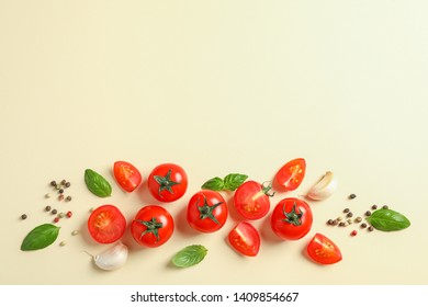 Flat lay composition with fresh cherry tomatoes, pepper, garlic and basil on color background, space for text. Ripe vegetables