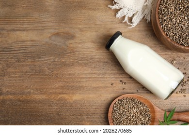 Flat lay composition with fresh hemp milk on wooden table. Space for text