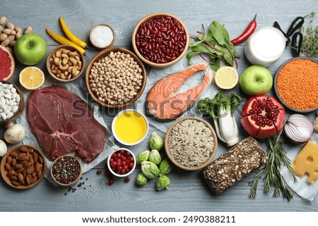Flat lay composition with fresh meat and other products for balanced diet on grey wooden table