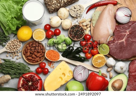 Flat lay composition with fresh meat and other products for balanced diet on grey marble table
