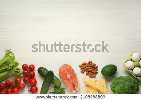 Flat lay composition with fresh organic products on white wooden table, space for text. Keto diet
