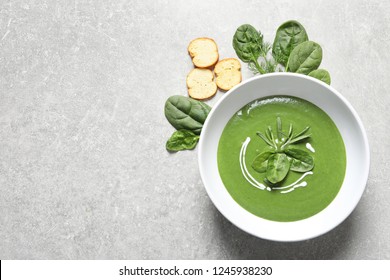 Flat lay composition with fresh vegetable detox soup made of spinach and space for text on table