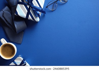 Flat lay composition with gift boxes, coffee cup, tie, glasses on dark blue background. Happy Fathers Day concept.