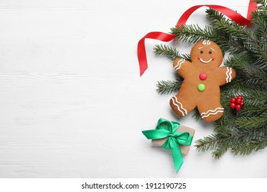 Flat lay composition with gingerbread man and Christmas decor on white wooden table, space for text - Powered by Shutterstock