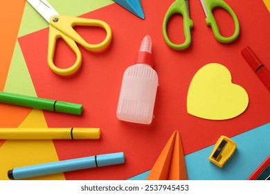 Flat lay composition with glue, scissors and other stationery on color background