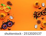 Flat lay composition with Halloween party decorations, kids eyeglasses, pumpkins, spiders, bats on orange background.