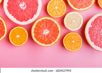 Flat lay composition with halves of different citrus fruits on pink background.. Space for text