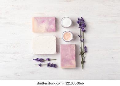 Flat lay composition with handmade soap bars and ingredients on white wooden background - Powered by Shutterstock