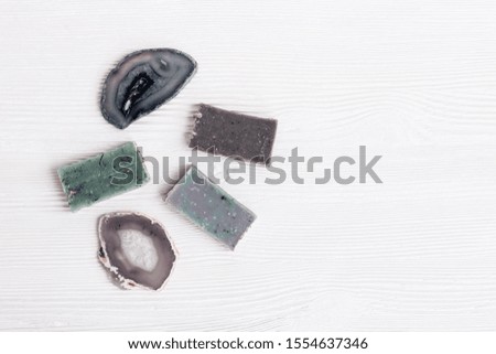 Flat lay composition handmade soap bars for bathroom and natural stones agate. Spa, aromatherapy and body care treatment concept. Top view with copy space. 