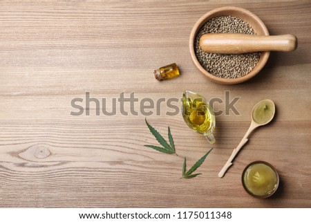 Flat lay composition with hemp lotion and space for text on wooden background