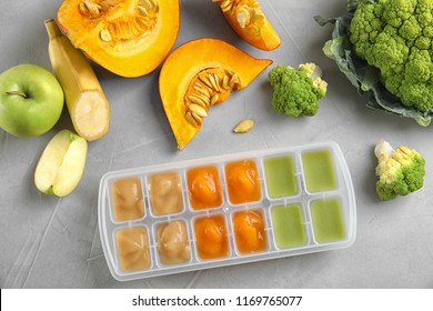 Flat Lay Composition With Ice Cube Tray Of Baby Food On Gray Background