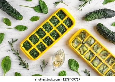 Flat lay composition with ice cube trays and herbs on white wooden background - Powered by Shutterstock