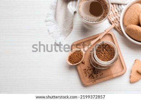 Flat lay composition with instant coffee on white wooden table. Space for text