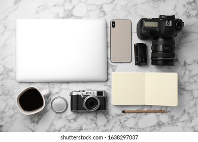 Flat lay composition with laptop, cameras and smartphone on white marble table. Designer's workplace - Powered by Shutterstock