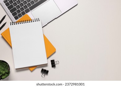 Flat lay composition with laptop and different stationery on white desk, space for text. Home office