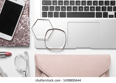 Flat lay composition with laptop, mobile phone and fashion blogger's stuff on white background