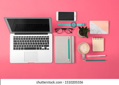 Flat lay composition with laptop and office tools on pink background