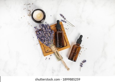 Flat lay composition with lavender flowers and natural cosmetic on white marble background