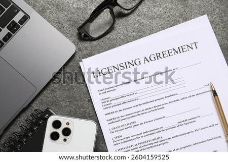 Flat lay composition with licensing agreement document on gray textured table