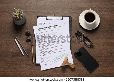 Flat lay composition with licensing agreement documents on wooden table