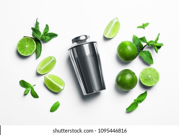 Flat lay composition with lime, mint and shaker on light background. Refreshing beverage ingredients