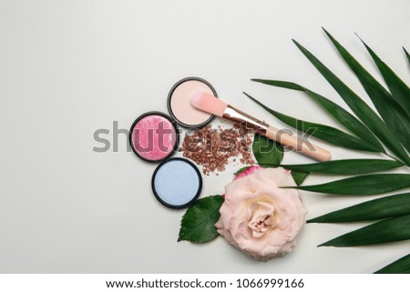 Flat lay composition with makeup brush, cosmetic products  and rose on white background
