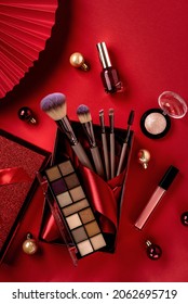 Flat Lay Composition With Makeup Products In Red Giftbox And Christmas Decor On Red Background. Christmas Sale Of Beauty Products Concept. 