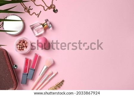 Flat lay composition with makeup products on pink background, space for text