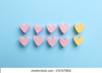 Flat lay composition with marshmallow hearts on light blue background. Pareto principle concept