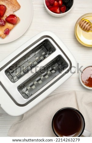 Flat lay composition with modern toaster on white wooden table