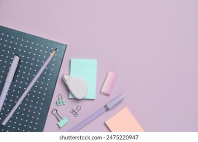 Flat lay composition with notebook and different stationery on violet background