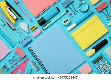 Flat lay composition with notebook and different stationery on light blue background