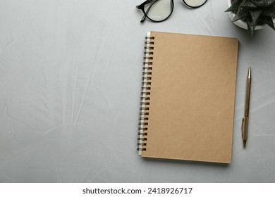 Flat lay composition with notebook on light textured table. Space for text