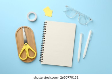 Flat lay composition with notebook on light blue background