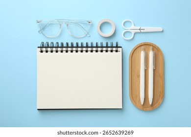 Flat lay composition with notebook on light blue background