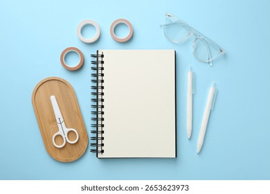 Flat lay composition with notebook on light blue background