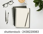 Flat lay composition with notebooks and coffee on white table